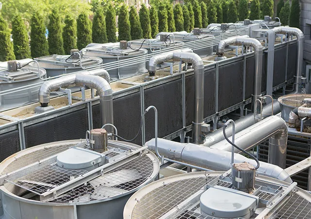 Commercial heating system on a rooftop with pipes and cooling fans.
