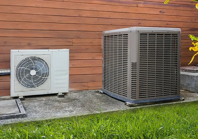 Two outdoor AC units side-by-side on a concrete slab, related to Cooling System Repair.