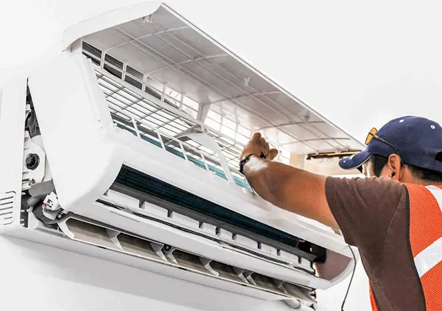 Technician servicing an indoor air conditioning unit.
